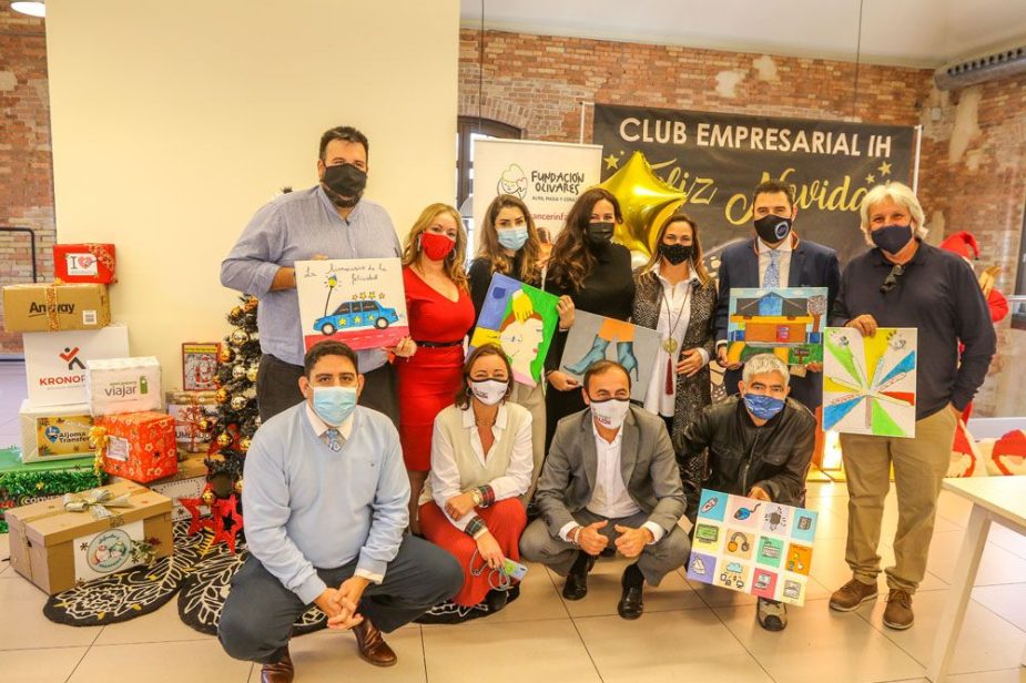 Algunos asistentes al evento enseñan las pinturas de los niñ@os